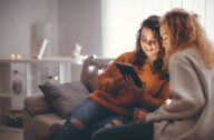 Young woman in domestic interior watching something on tablet PC
